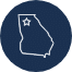 White outline of the state of Georgia on a dark blue circular background, with a star marking a location in the northern part of the state.