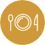 A gold circular icon with a white outline of a spoon on the left, a plate in the center, and a fork on the right, representing dining or food.
